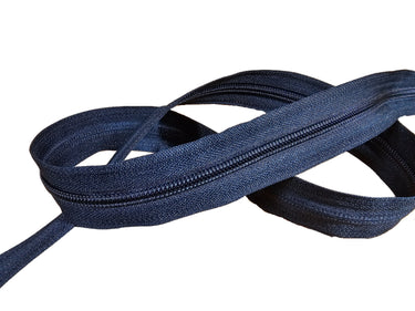 Navy blue nylon coil zipper by the yard, displayed on a white surface.