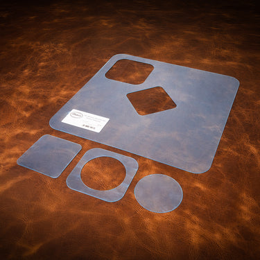 A set of blue acrylic templates used for creating a custom leather decanter set, laid out on a brown leather textured background.