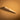 A wooden edge slicker for leather projects laid out on a textured light brown leather background.