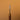 A paint roller tool with a textured metal tip and sturdy wooden handle, used for applying paint to leather surfaces, laid out on a solid light brown background.