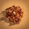 A pile of copper rivets used for leather crafting and other craft projects. Laid out on a brown textured leather background.