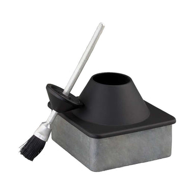 Black and gray ceramic glue pot for storing glues and adhesives, sitting along side a brush used to seal the container. Laid out on a white background.