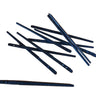 A collection of two prong lacing needles laid out on a flat white surface.