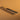 A replacement metal blade for a skiving knife, which is used for leather projects and crafting. Laid out on a brown textured leather background. 