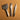 A set of 3 buck-stitching chisels used for stitching with leather projects in the large size. Laid out on a light brown textured leather background. 
