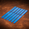 A set of blue acrylic templates used for creating custom watch bands made from leather. Laid out on a brown textured leather background. 