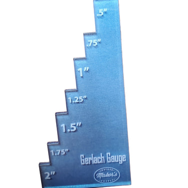 A metal Gerlach Gauge placed on a leather surface, used for adjusting strap cutters in crafting.